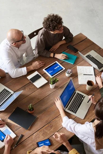 Team members discussing digital graphs on a tablet in a modern office setting.
